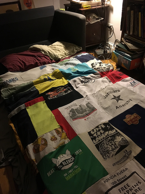 bed with quilt made out of running  t-shirts