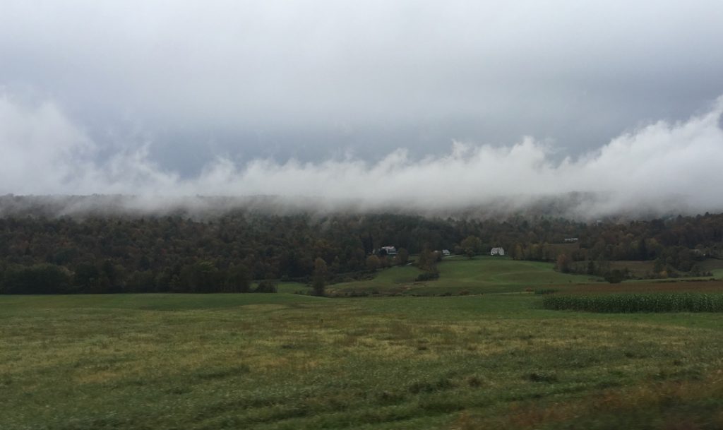 clouds hanging over a rural farming valley