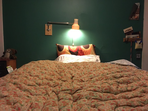 picture of my bed taken from the foot of it, featuring a comfy looking comforter and some groovy looking pillowcases.