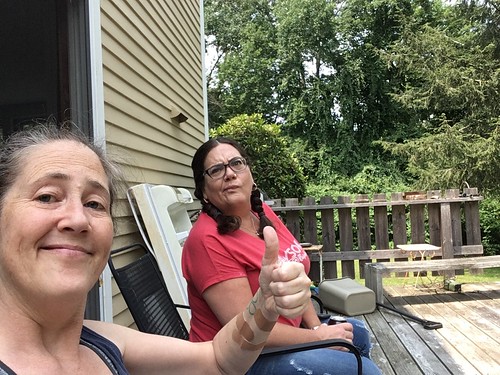 me and kate sistting on the back porch of my mom's house. I am making the thumbs up sign, she is making a face.