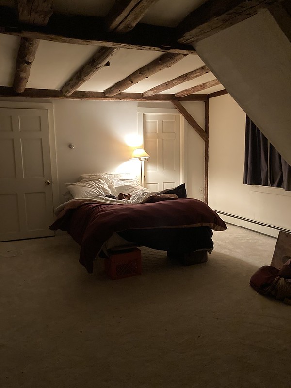 a bed which is really just a piece of plywood up on milk crates in the middle of an entirely empty room